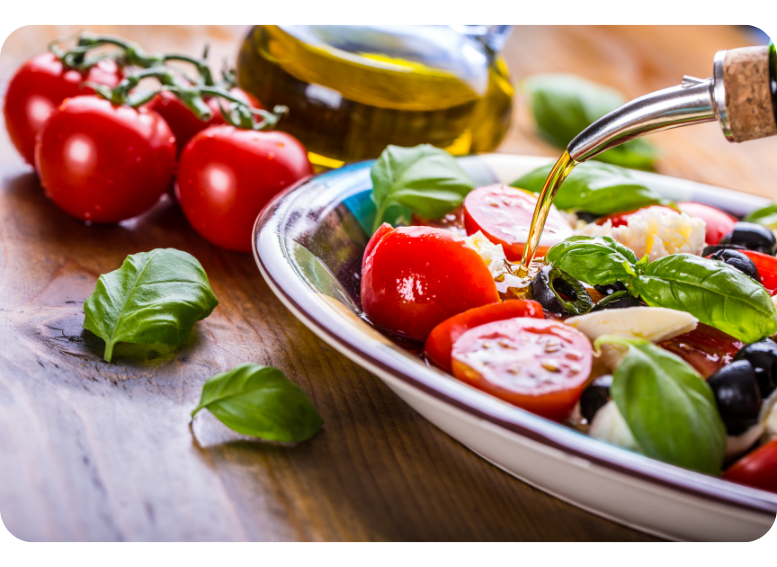 Świeża sałatka z pomidorami, oliwą z oliwek i bazylią jako przykład dania z diety śródziemnomorskiej w ofercie cateringu dietetycznego.
